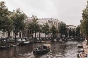 Home Rondvaartboot in Amsterdam met passagiers die genieten van het uitzicht op de grachten en historische architectuur